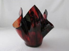 A red and black vase sitting on top of a table.