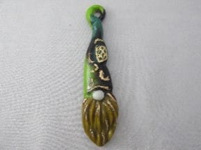 A gnome is hanging on the side of a spoon.