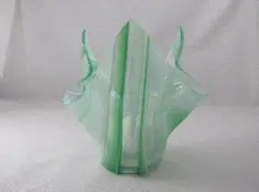 A green glass sculpture sitting on top of a table.