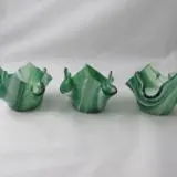 Three green ceramic animals are sitting on a table.