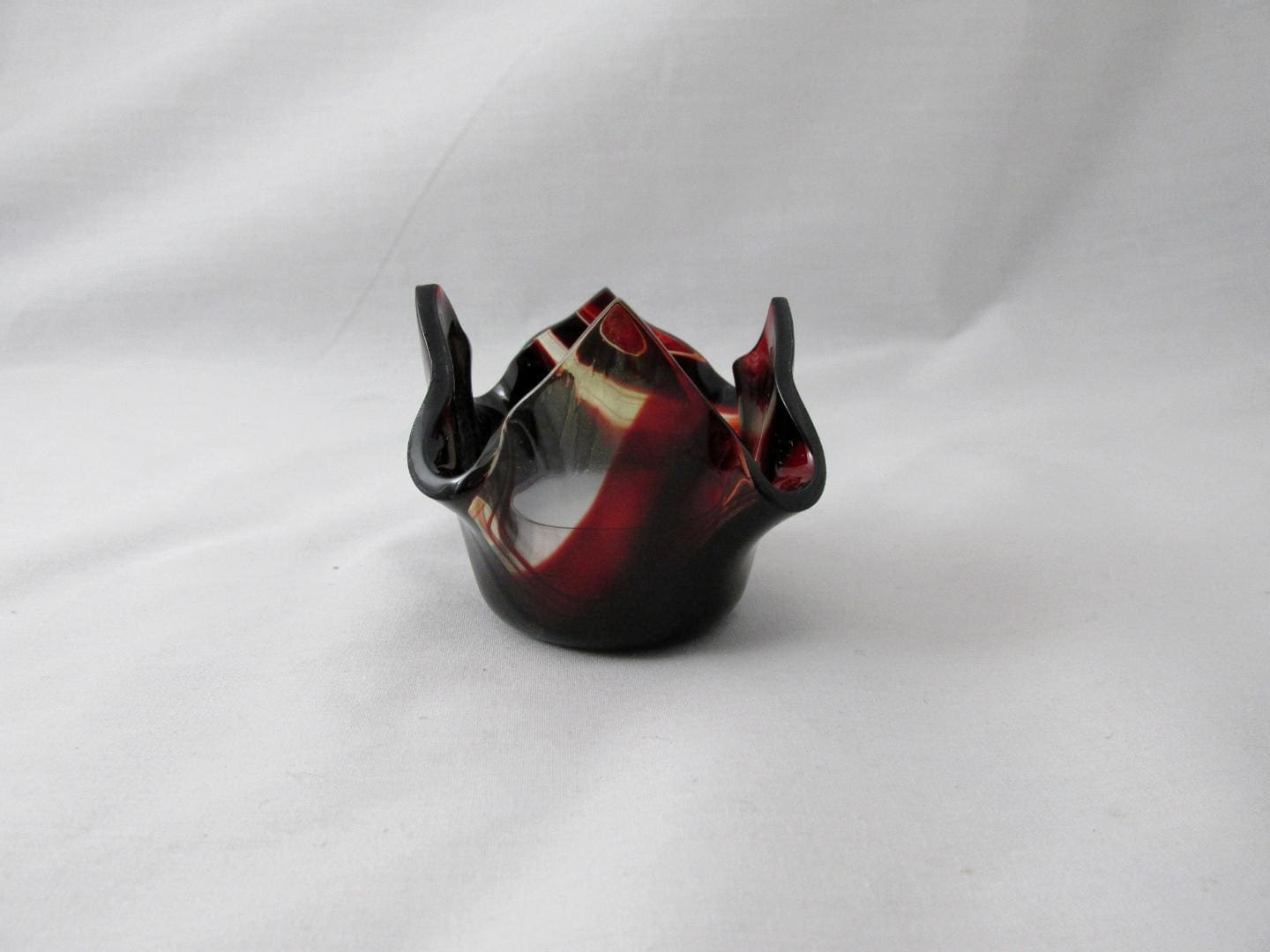 A small ceramic candle holder with horns on top of it.