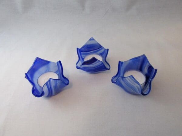 Three blue and white plastic objects sitting on top of a table.