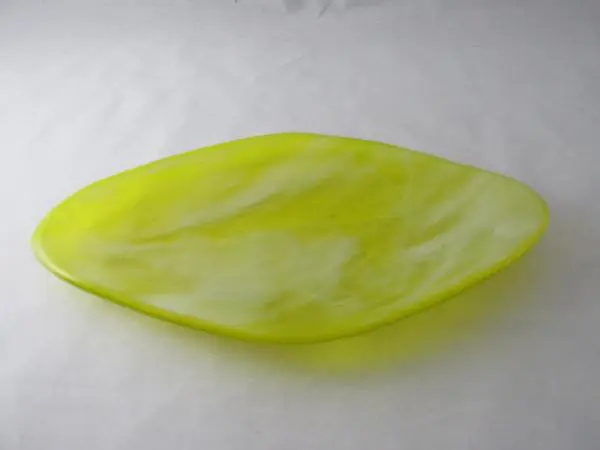 A yellow glass dish sitting on top of a table.