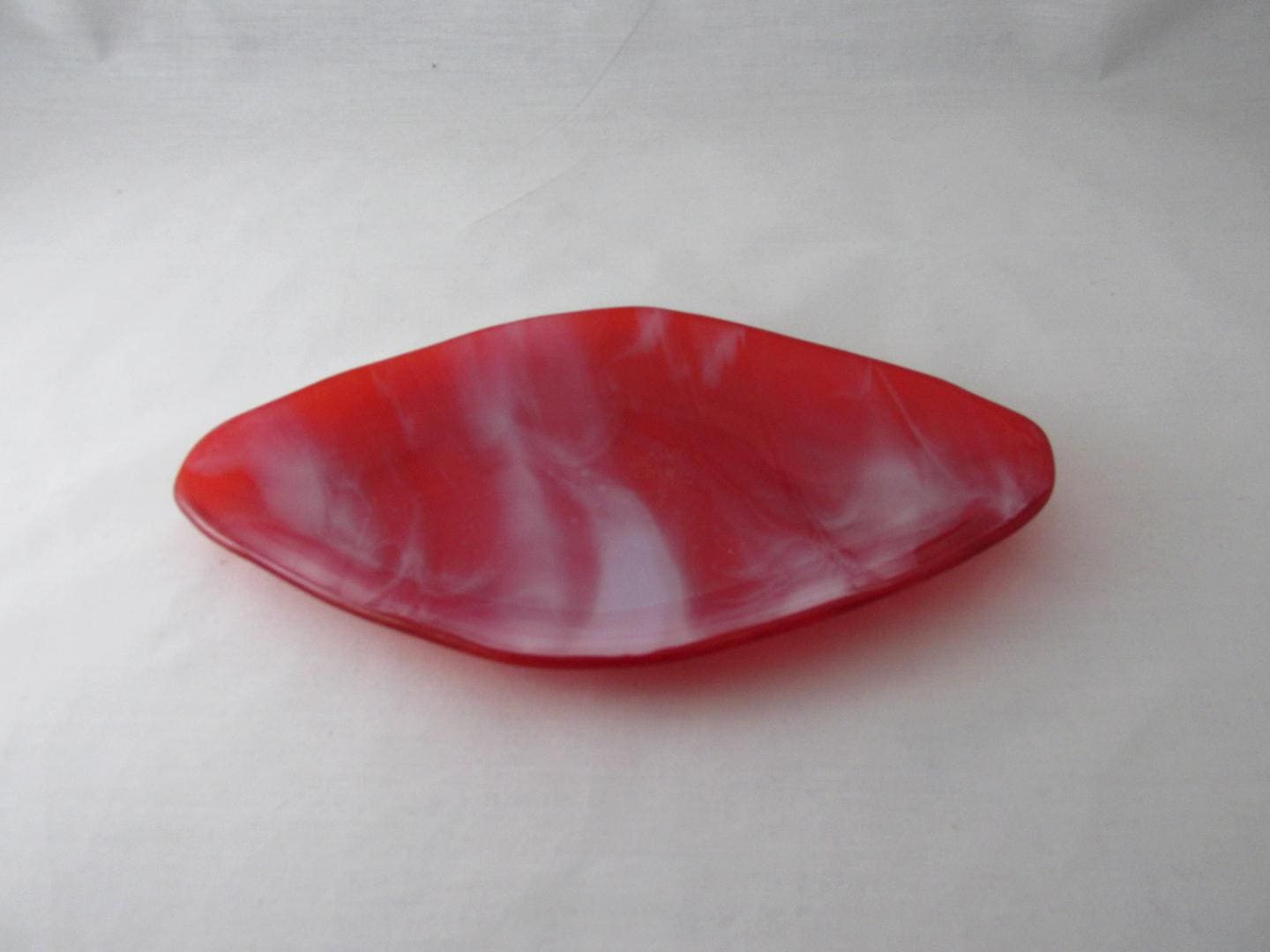 A red and white dish on top of the floor.