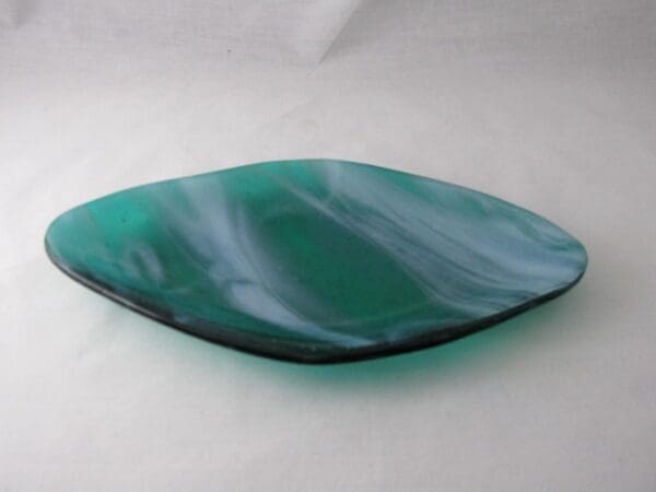 A green glass dish sitting on top of a table.