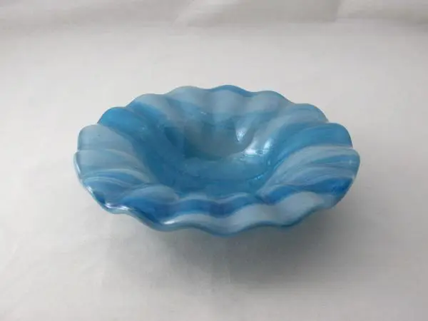 A blue bowl with wavy edges on top of it.