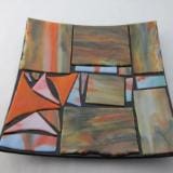 A square plate with an abstract design on it.