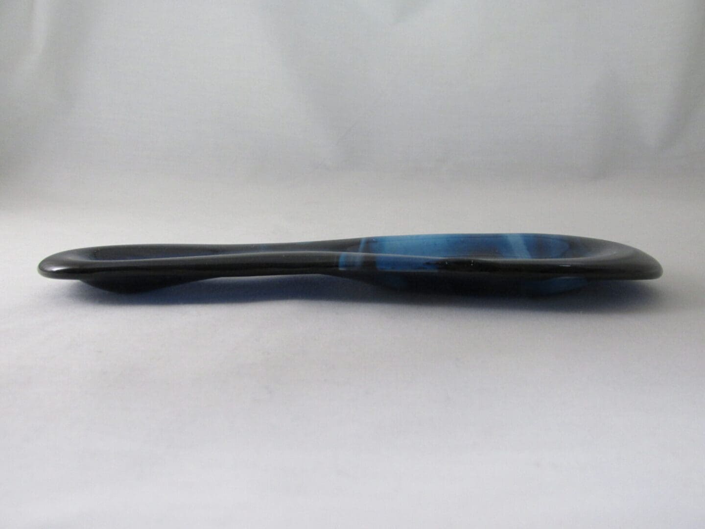 Blue and black spoon on white background.