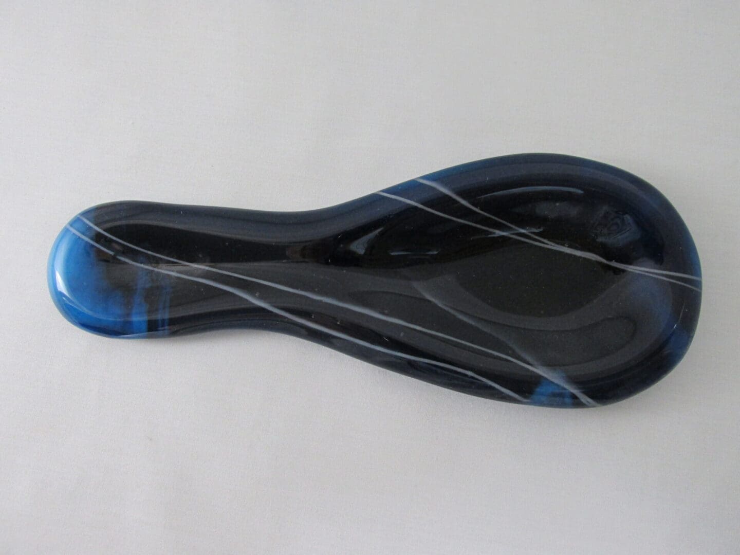Dark blue glass spoon rest with stripes.
