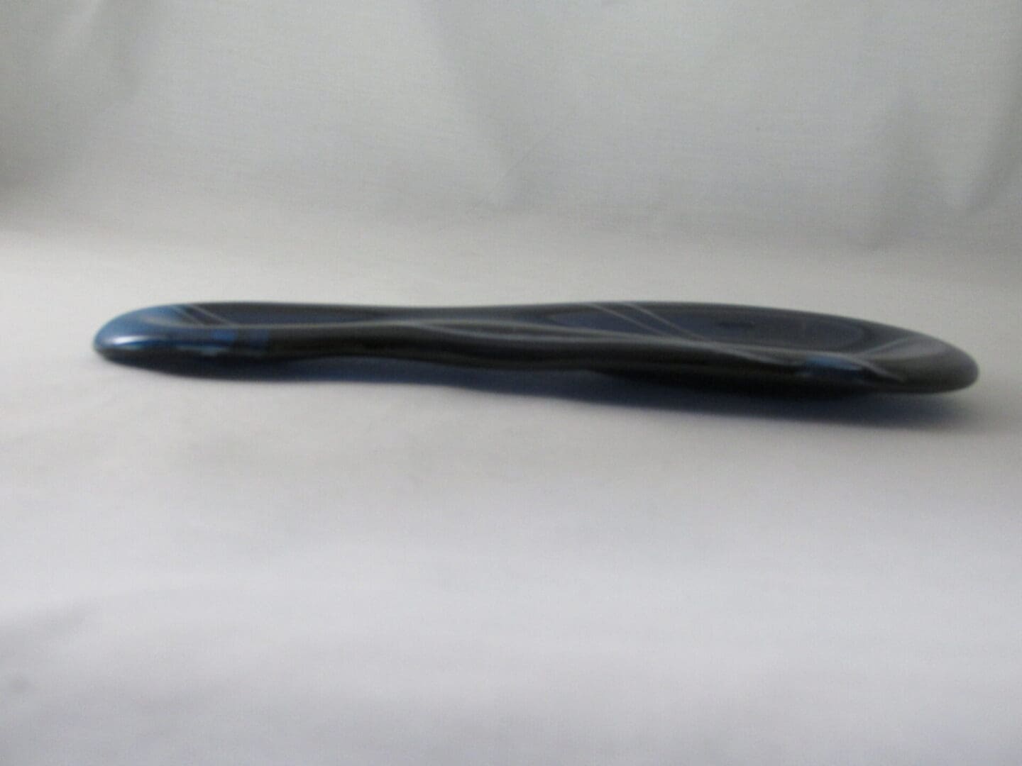 Dark, sleek object on light background.
