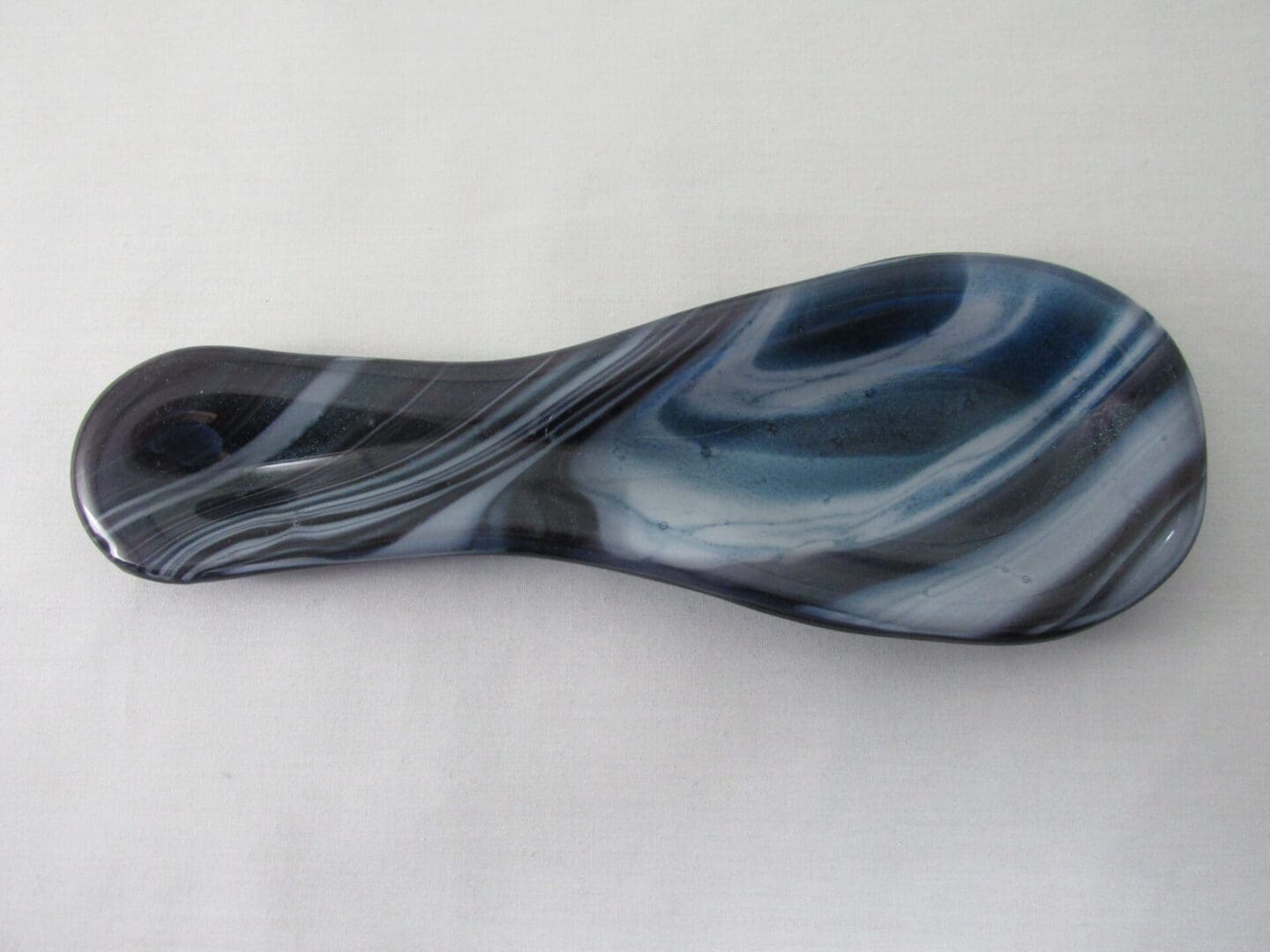 Marble-patterned glass massage tool on white background.