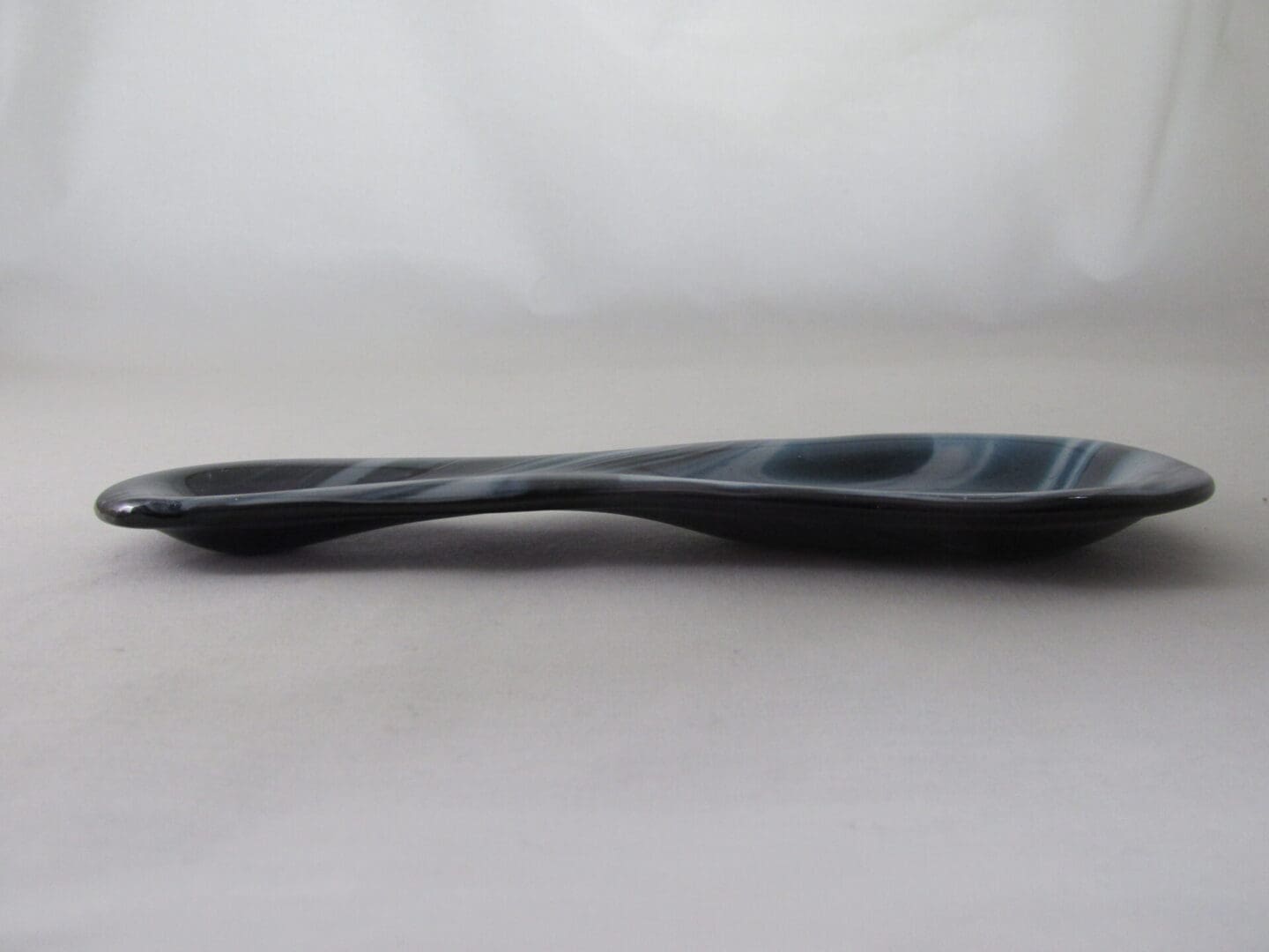 Dark, flat stone with curved shape.