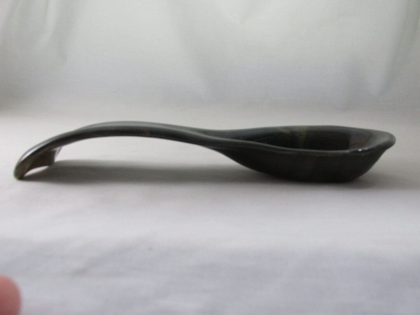 Curved black spoon rest on surface.