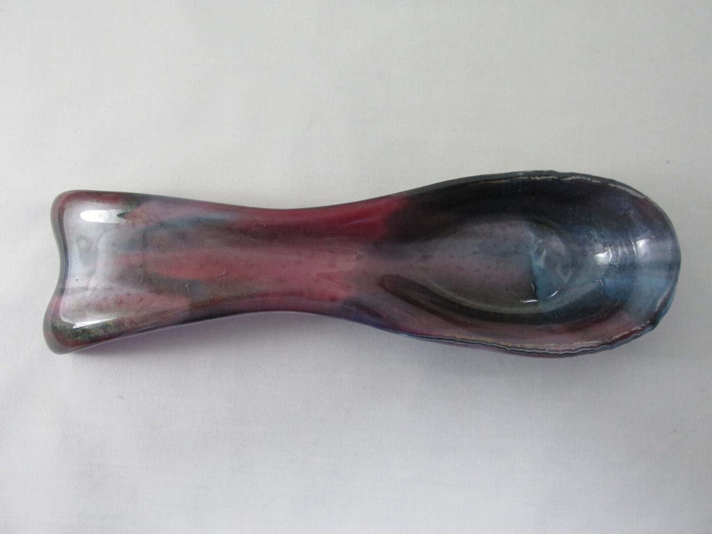 Ceramic spoon rest with glossy finish.