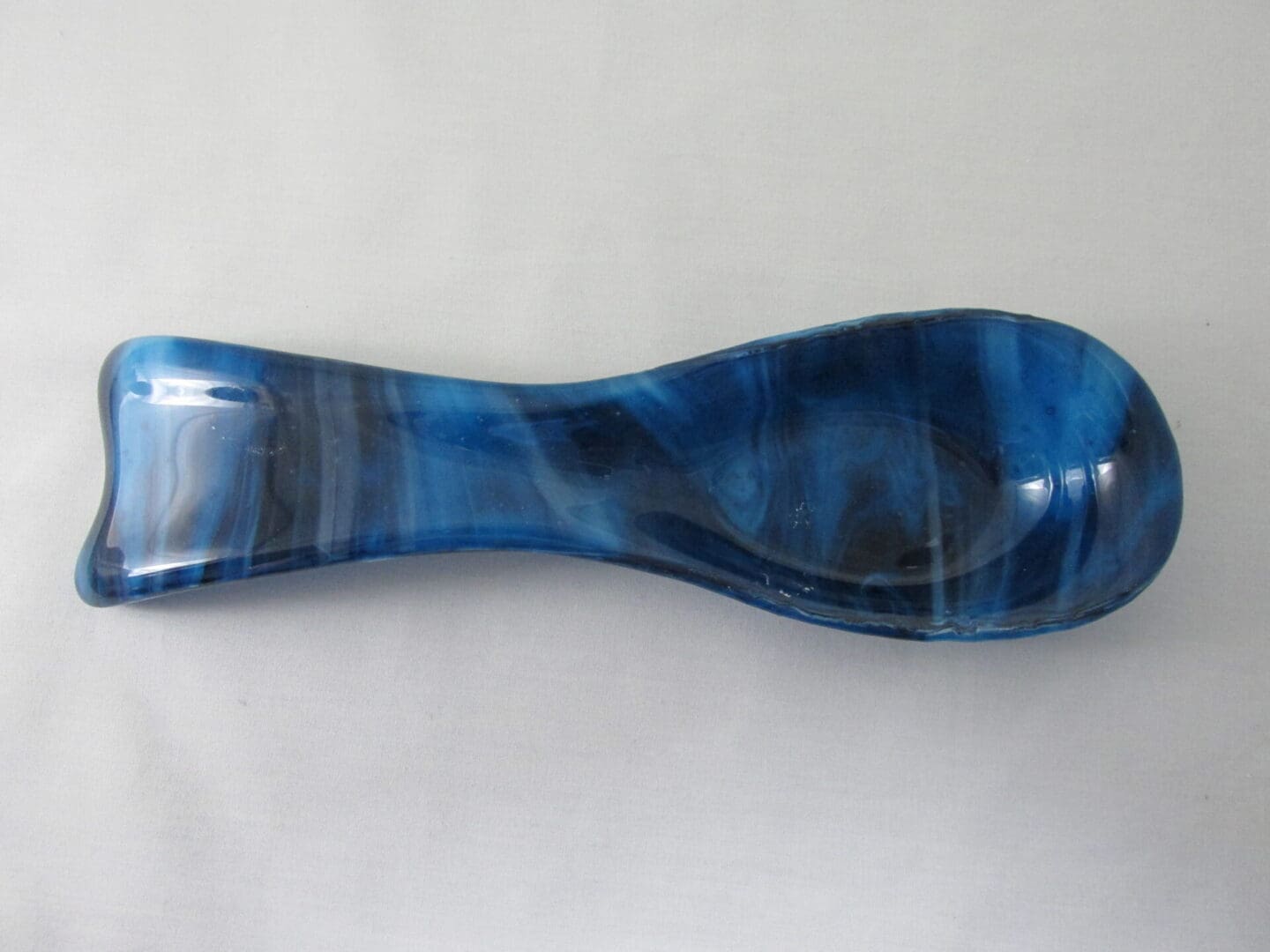 blue glass spoon rest on white background