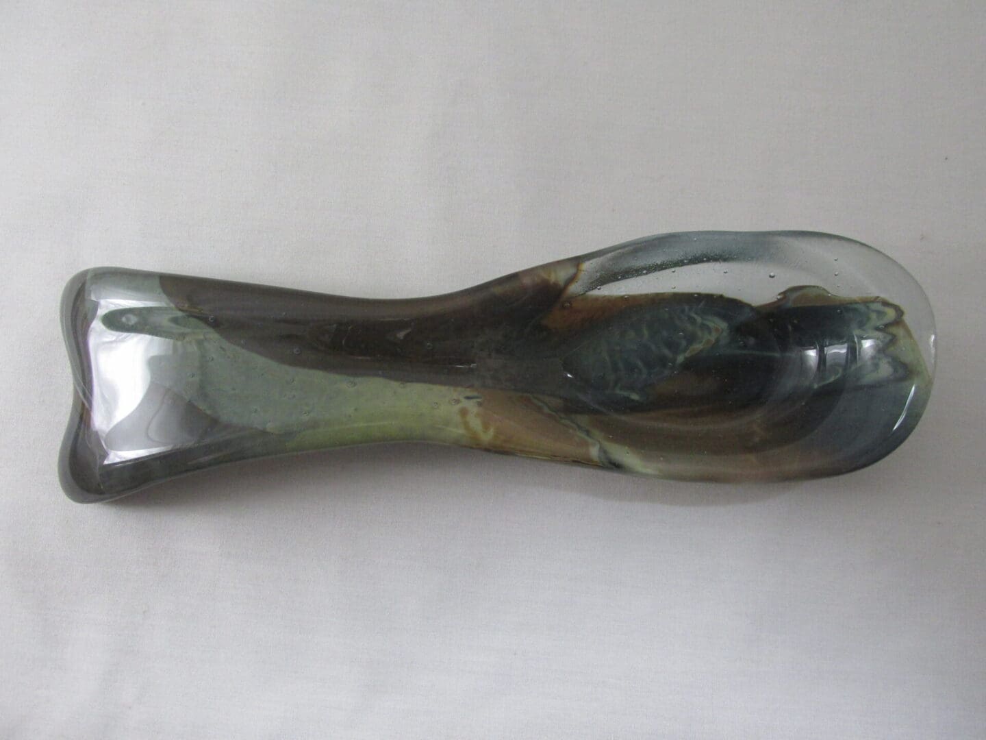 Glass sculpture with abstract design on table.