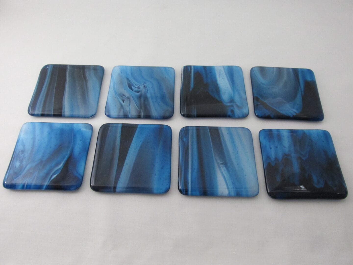 Two rows of four blue marbled coasters
