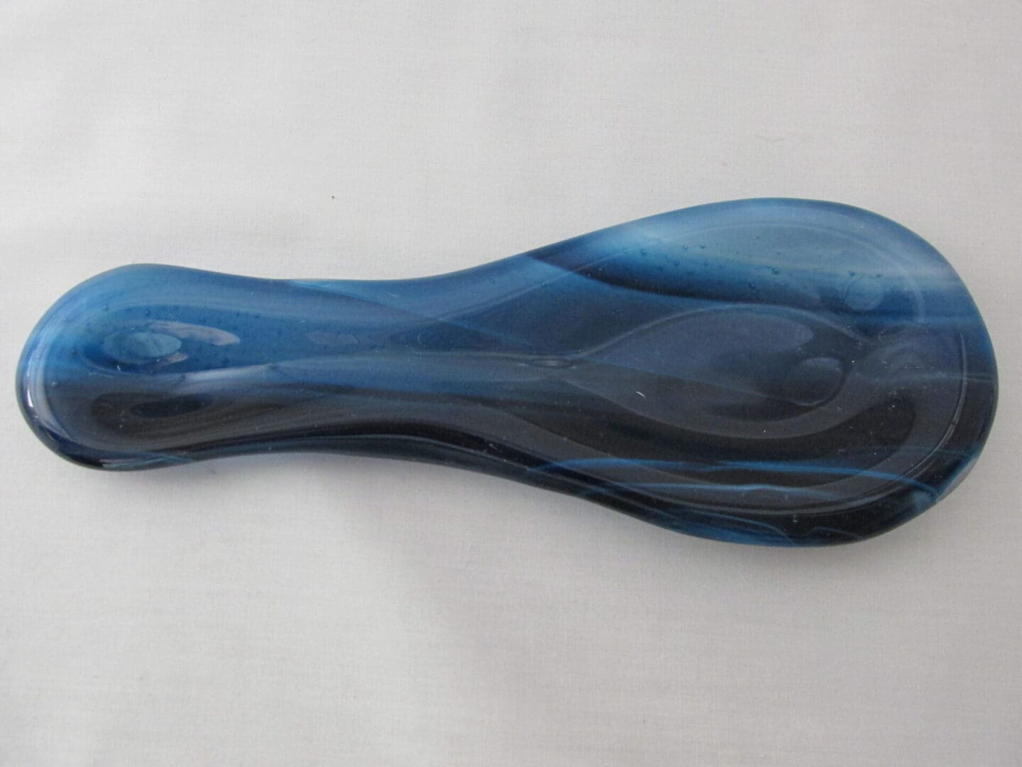 Curved blue glass spoon rest with swirls