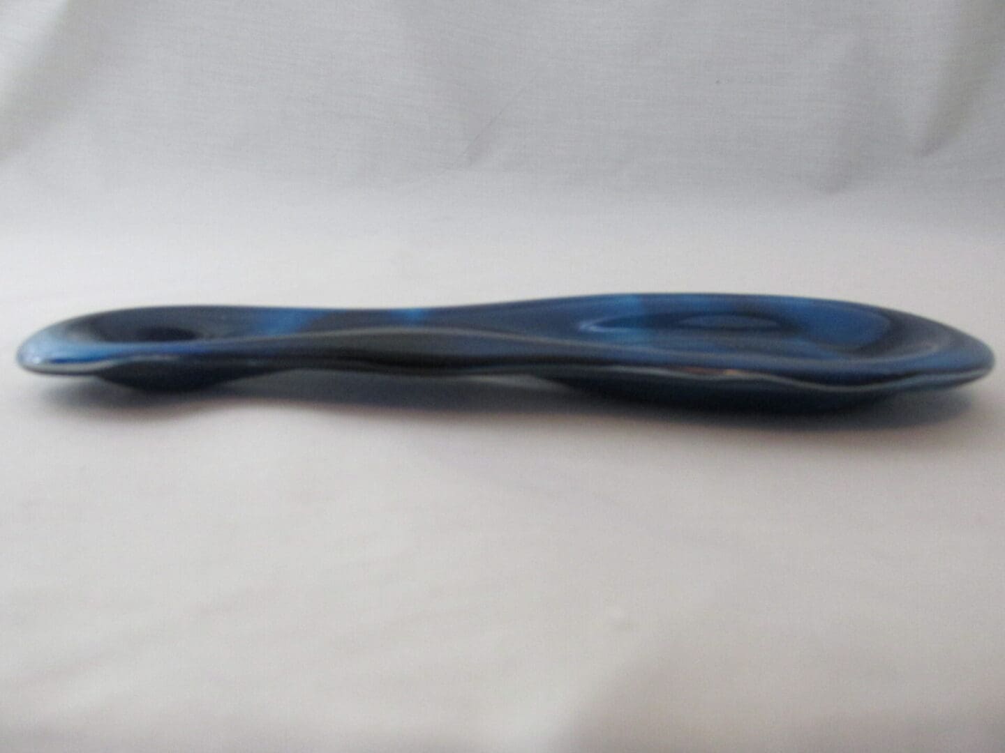 Blue glass spoon rest with glossy curved shape