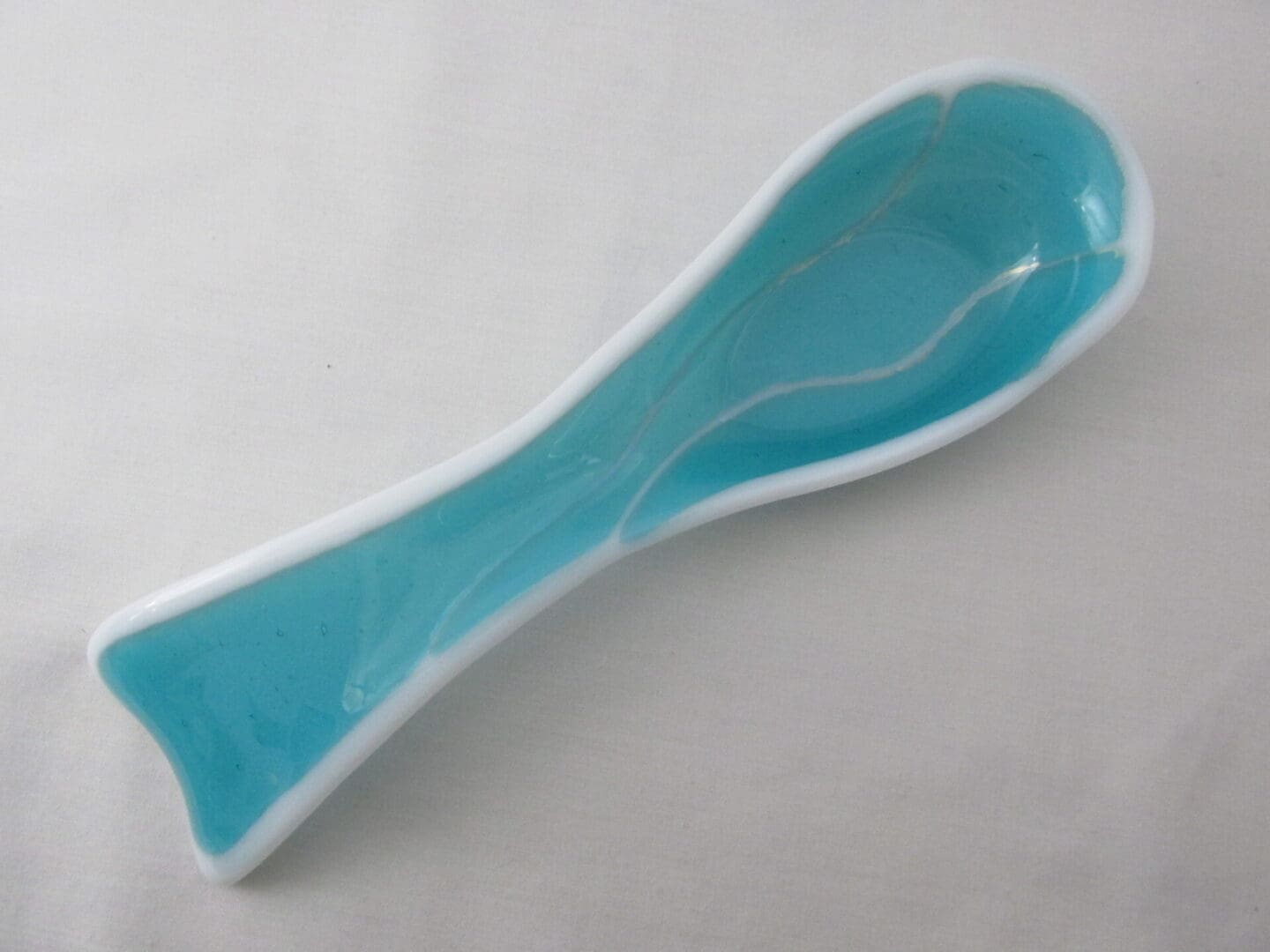 turquoise ceramic spoon rest with white rim
