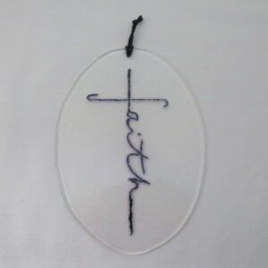 Oval glass ornament with embroidered cross