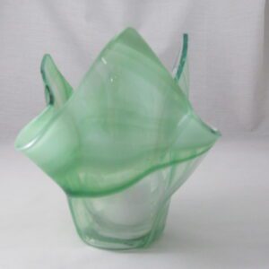 Translucent green ruffled glass vase on white